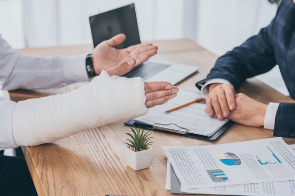 A person with a broken arm speaking to a Houston construction accident lawyer. How much is my construction accident case worth?